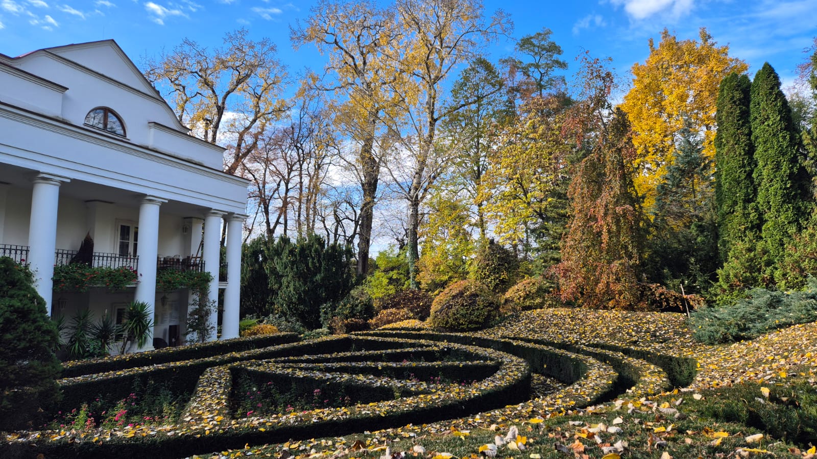 Dwór i otaczająca go kolorowa roślinność jesienią